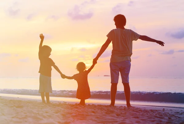 Padre con i bambini sagome divertirsi al tramonto — Foto Stock