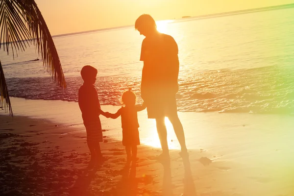 Батько і двоє дітей ходять на заході сонця — стокове фото