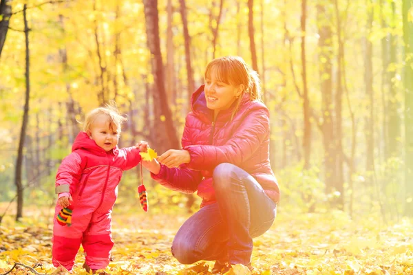 mother and cute little daughter in autumn fall