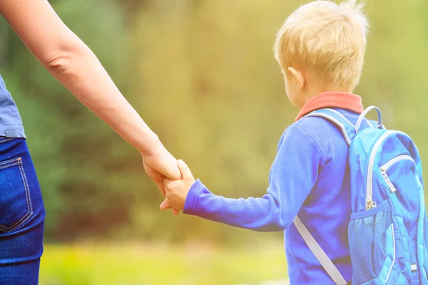 Mother holding hand of little son with backpack outdoors — Stock Photo, Image