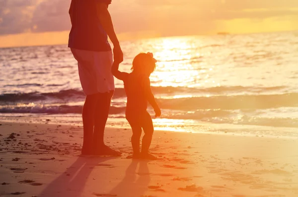 Silhouettes de père et petite fille marchant au coucher du soleil — Photo