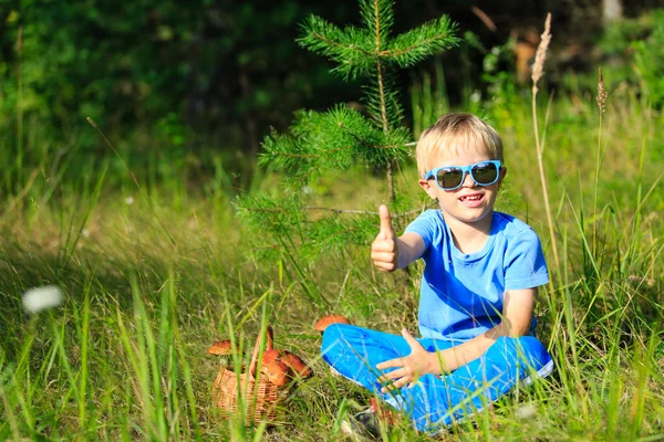 Niño recogiendo setas en el bosque verde — Foto de Stock