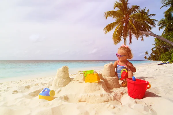 Schattig klein meisje spelen met zand op tropische strand — Stockfoto