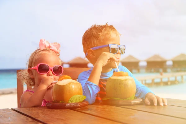 Niño y niña bebiendo cóctel de coco en un resort tropical —  Fotos de Stock