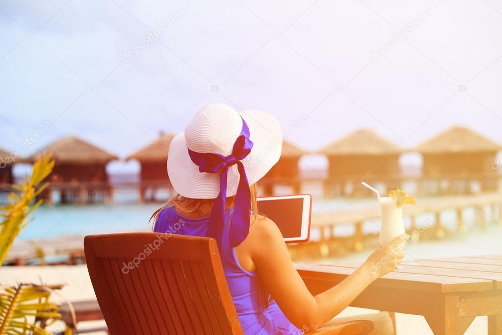 young woman with cocktail and touch pad at luxury resort