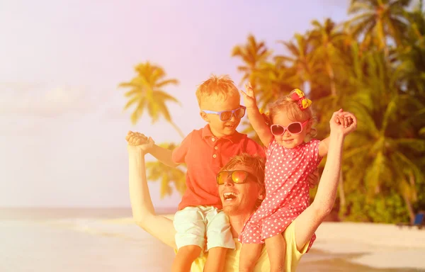 Omuzlarında eğleniyor tropikal beach adlı iki çocuğu olan baba — Stok fotoğraf