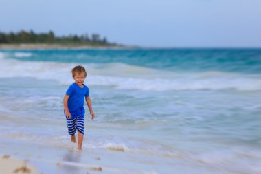 küçük çocuk kum tropikal plaj üzerinde çalışan