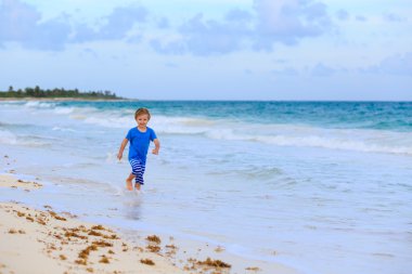 küçük çocuk kum tropikal plaj üzerinde çalışan