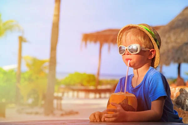 Menino bebendo coquetel de coco na praia — Fotografia de Stock