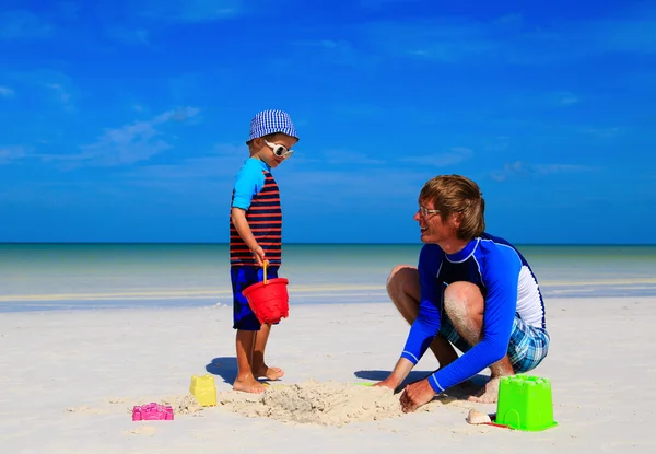 Pai e filho construindo castelo de areia na praia — Fotografia de Stock