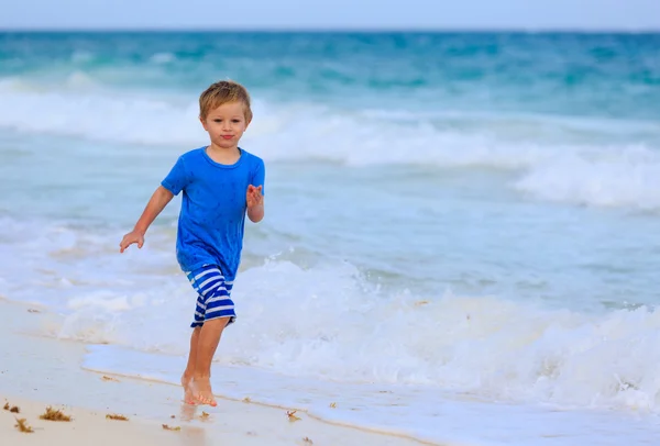 Mały chłopiec biegną na piasek plaża tropikalny — Zdjęcie stockowe