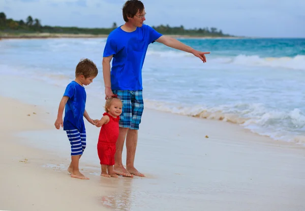 Vader en twee kinderen praten op het strand — Stockfoto