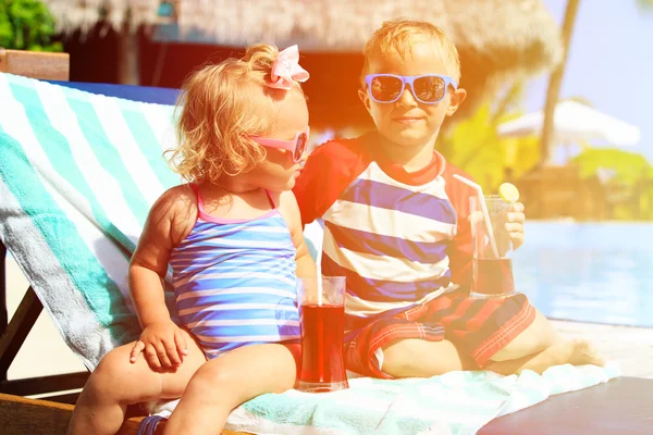 I bambini si rilassano sulla spiaggia tropicale e bevono succhi — Foto Stock
