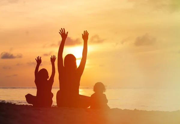 Mãe feliz com dois filhos se divertindo ao pôr do sol — Fotografia de Stock