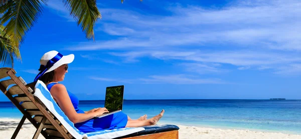 Молода жінка з ноутбуком на тропічному пляжі — стокове фото
