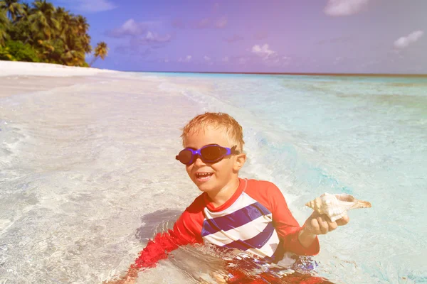 Piccolo ragazzo nuotare con conchiglia sulla spiaggia — Foto Stock