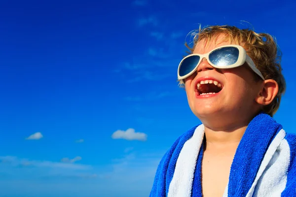 小さな男の子の笑いに包まれた空の浜辺タオル — ストック写真