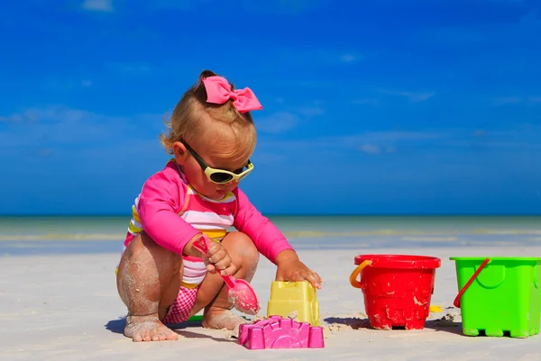 Toddler girl playing with toys on tropical beach — Stock Photo, Image