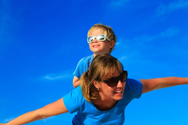 Mãe e filho jogando avião no céu azul de verão — Fotografia de Stock