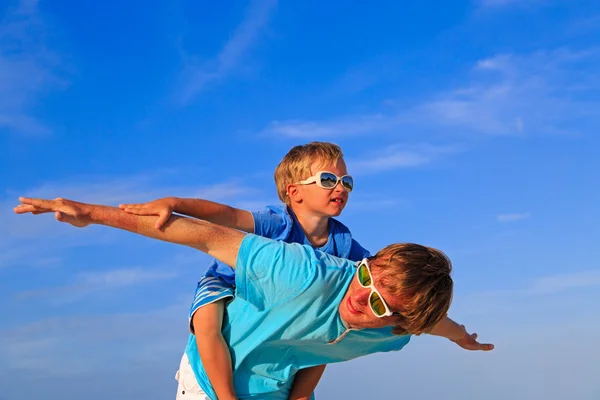 Vader en zoon spelen op blauwe zomer hemel — Stockfoto