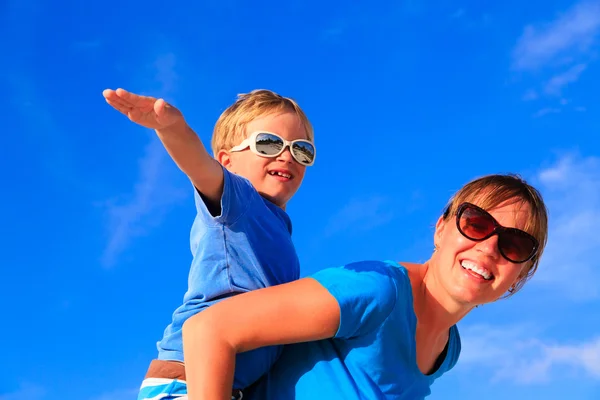 Mãe e filho jogando avião no céu azul de verão — Fotografia de Stock