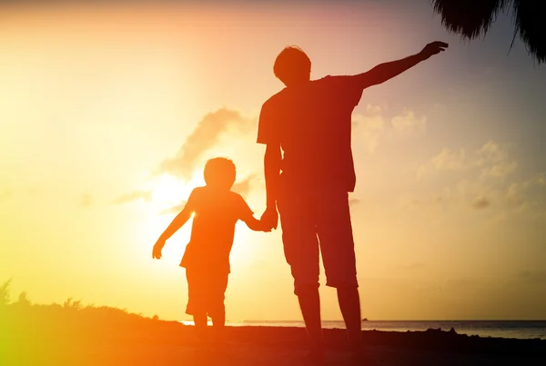 Father and son silhouettes play at sunset — Stock Photo, Image