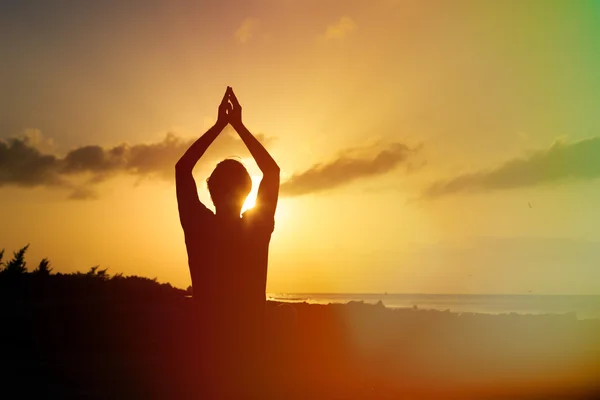 Sziluettjét fiatalember jóga naplementekor — Stock Fotó