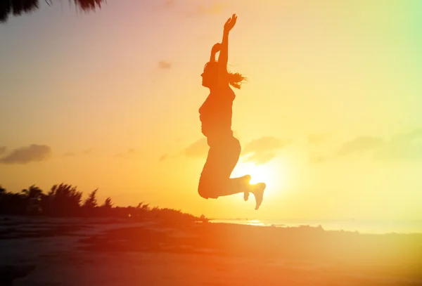 Silhouette di donna che salta sulla spiaggia — Foto Stock