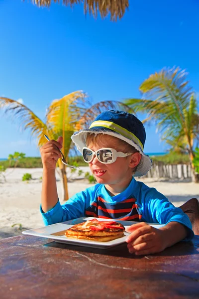 Menino comendo na praia café ao ar livre — Fotografia de Stock