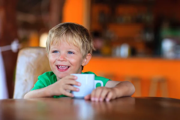 Heureux petit garçon boire du lait dans le café — Photo
