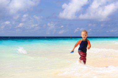 küçük çocuk kum tropikal plaj üzerinde çalışan