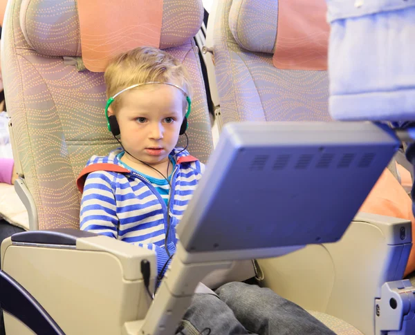 Pequeño niño viendo la televisión en vuelo — Foto de Stock