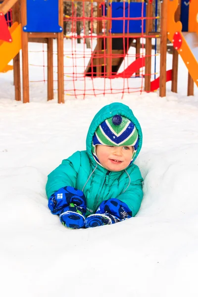 Μικρό αγόρι που διασκεδάζουν στην παιδική χαρά του χειμώνα — Φωτογραφία Αρχείου