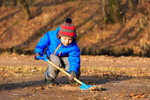 Niño pequeño cavando en el parque de otoño — Foto de Stock