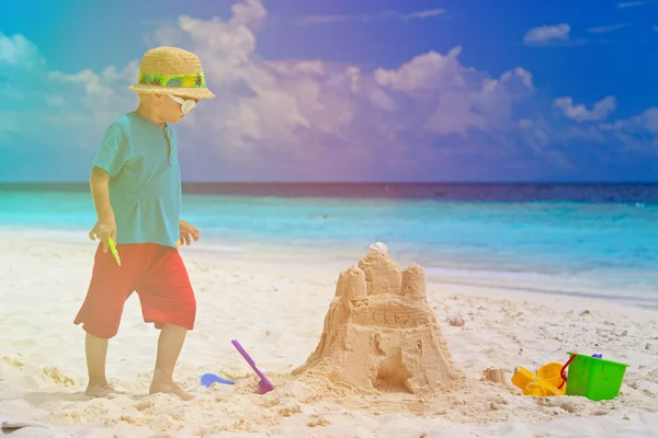 Niño pequeño edificio castillo de arena en la playa — Foto de Stock