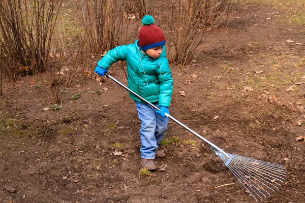 Little boy cleaning spring lawn — Stock Photo, Image