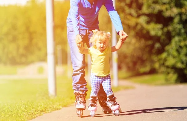 Father teaching little daugther to roller skate in summer — Stock Photo, Image