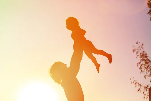 Sagome di padre e figlioletta che giocano al tramonto — Foto Stock