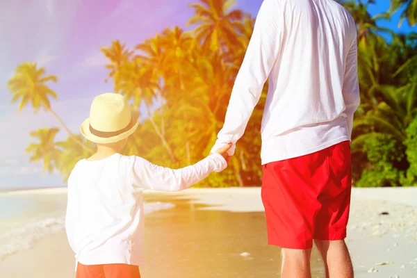 Piccolo figlio che tiene per mano i padri in spiaggia — Foto Stock