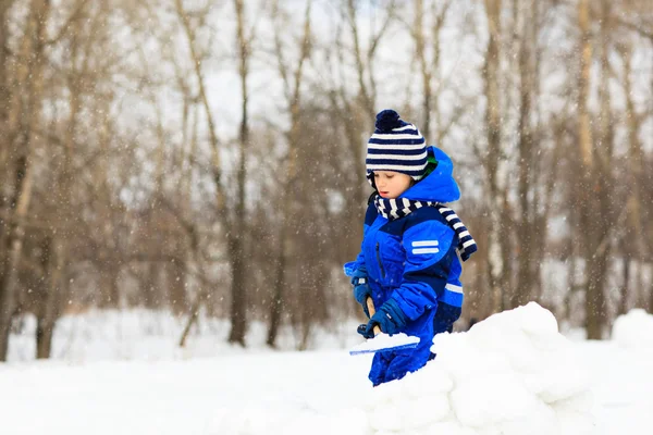 Kleiner Junge buddelt und spielt im Winterschnee — Stockfoto