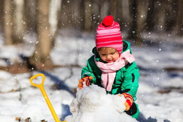 Menina cavando neve no inverno — Fotografia de Stock