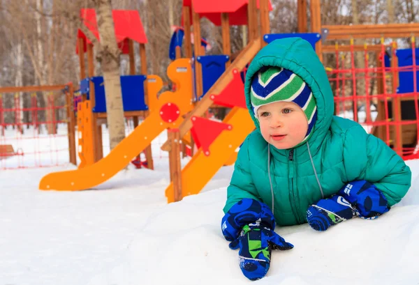 Μικρό αγόρι που διασκεδάζουν στην παιδική χαρά του χειμώνα — Φωτογραφία Αρχείου