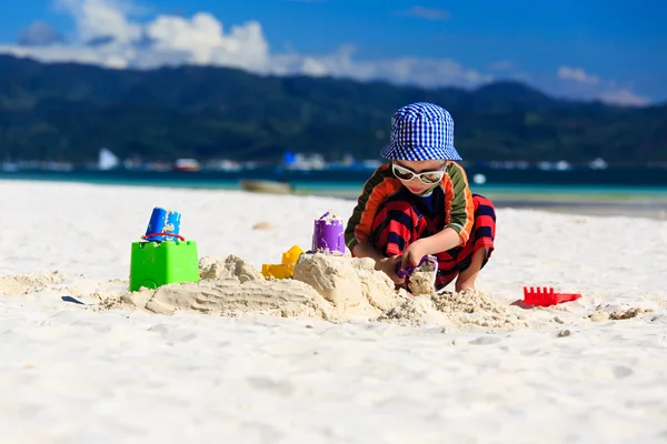 Bambino costruzione castello di sabbia sulla spiaggia — Foto Stock