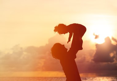 Baba ve küçük kızı siluetleri gün batımında