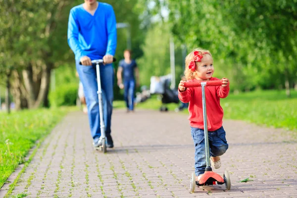 Vater und kleine Tochter fahren Roller — Stockfoto