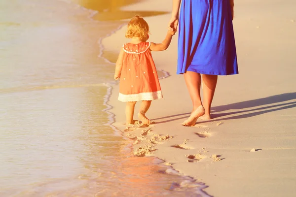 Mère et petite fille marchant sur la plage — Photo