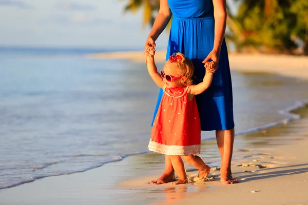 Madre e hija pequeña caminando en la playa de verano — Foto de Stock