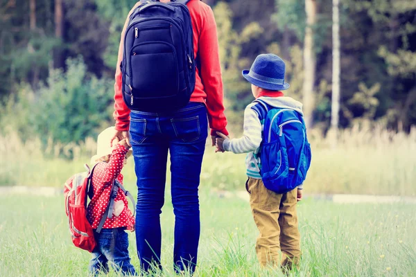 Modern som håller händerna på barn går till skolan eller dagis — Stockfoto