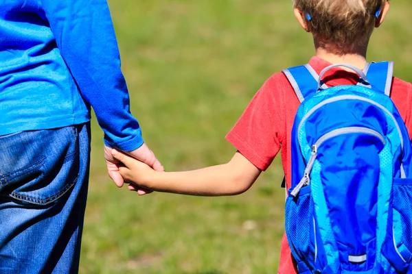 Padre che tiene per mano il piccolo figlio con lo zaino all'aperto — Foto Stock