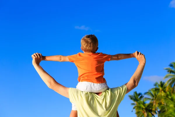 Щасливий батько і маленький син на плечах грають на пляжі — стокове фото